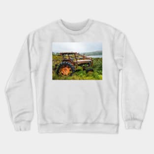 Old rusty tractor overgrown with weeds near a lake Crewneck Sweatshirt